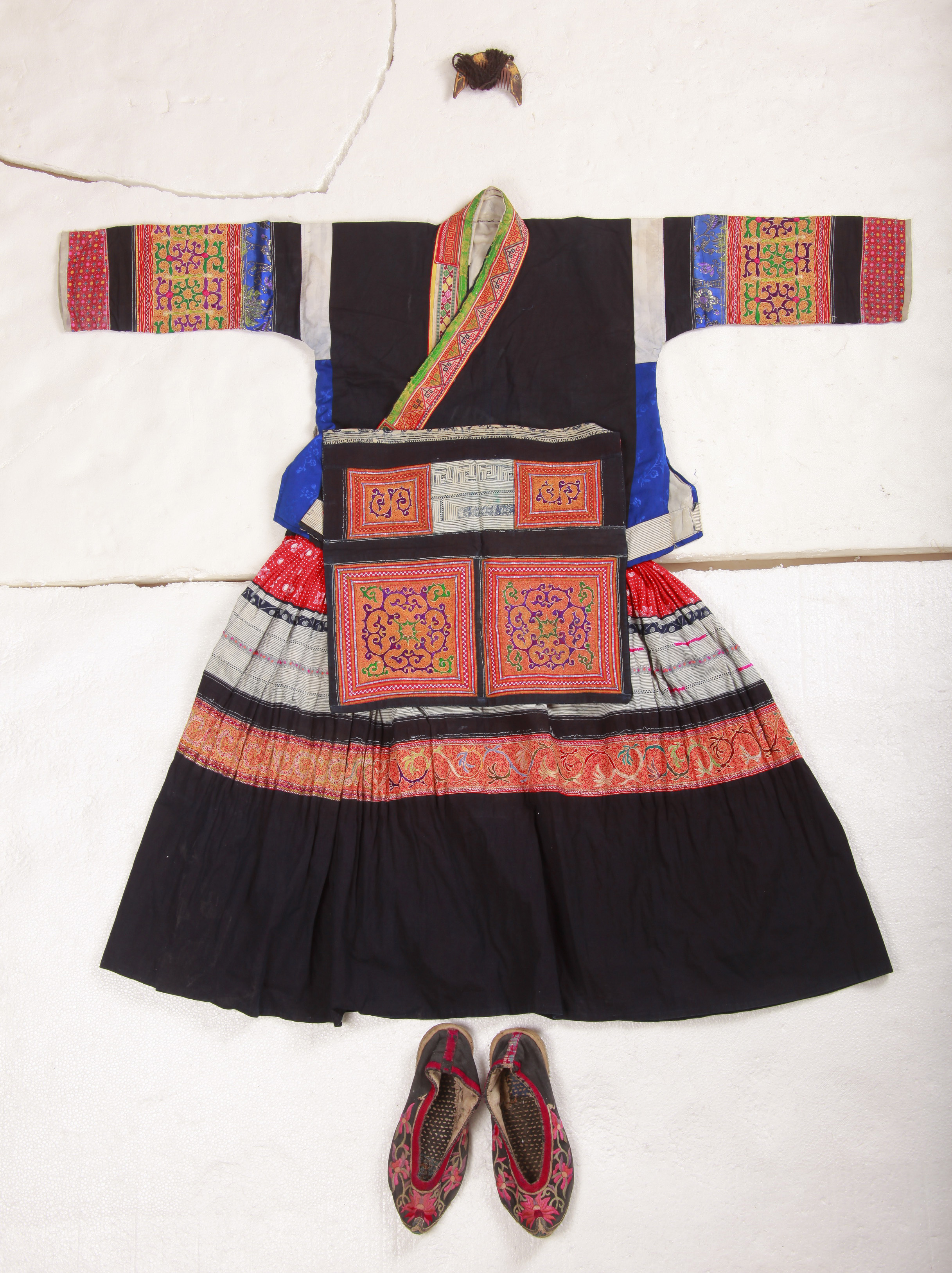 Young Miao girl’s embroidered ensemble with baby