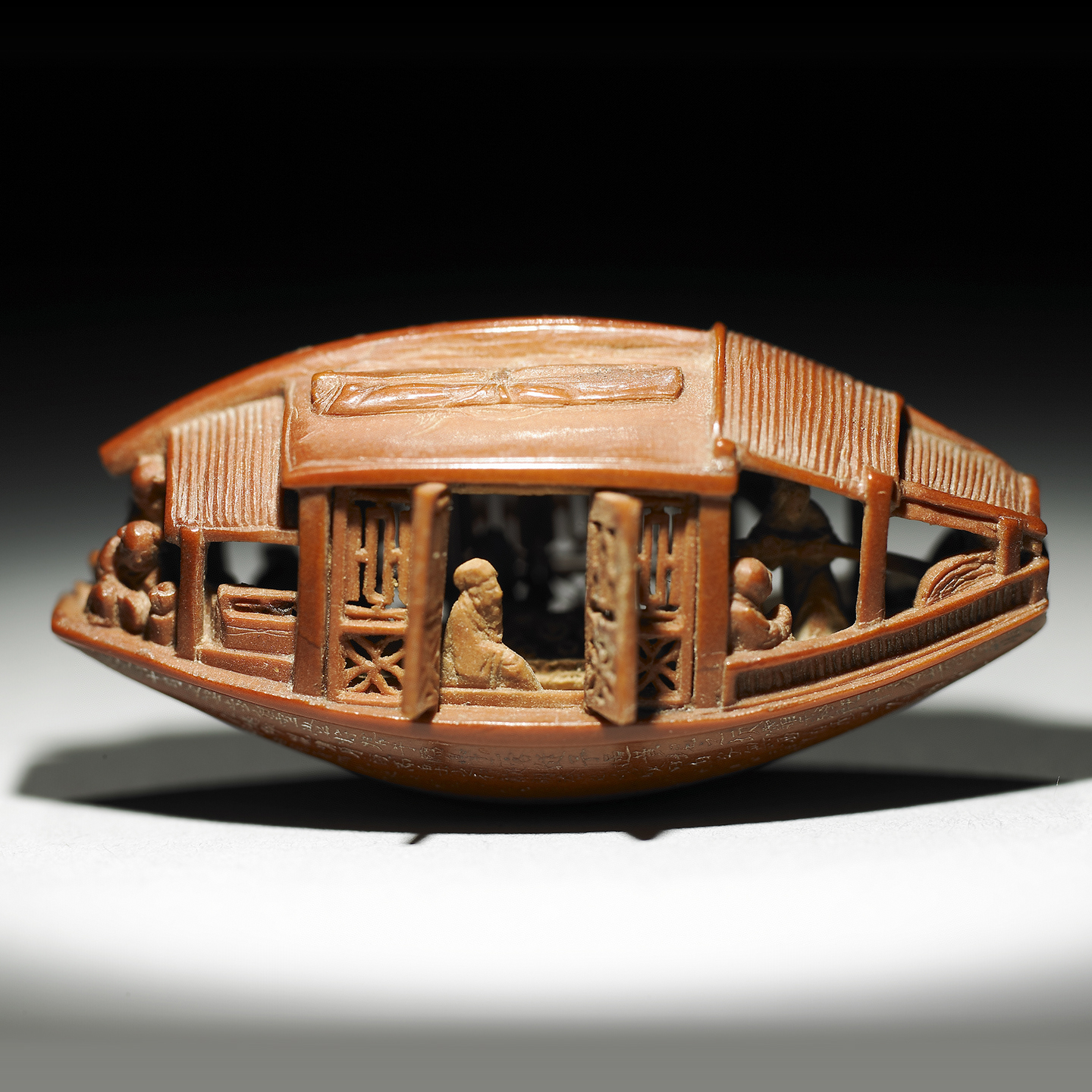 Carved olive pit in the form of a boat