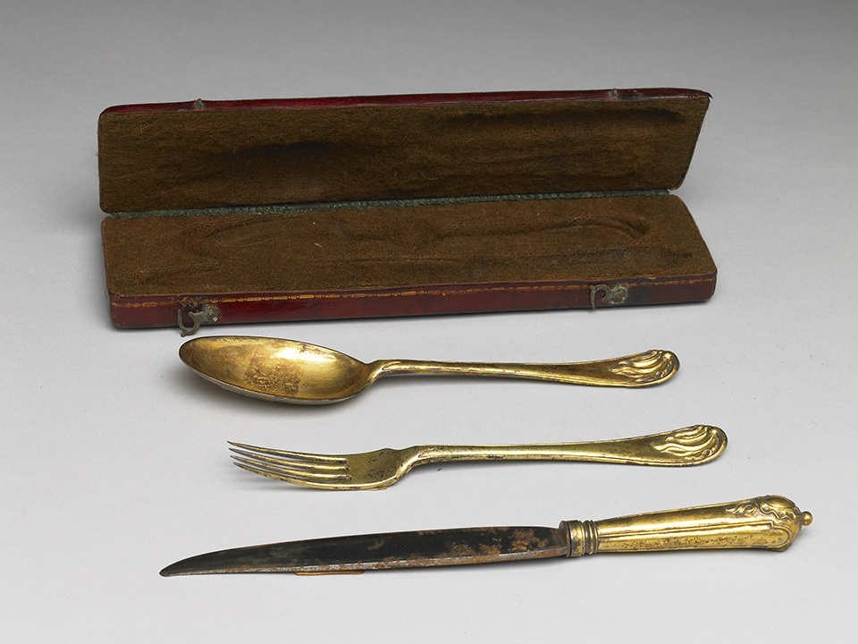 Gilt eating utensils, leather case, wood box