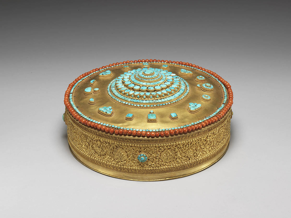 Tibetan gold mandala with turquoise and coral inlays in a leather case