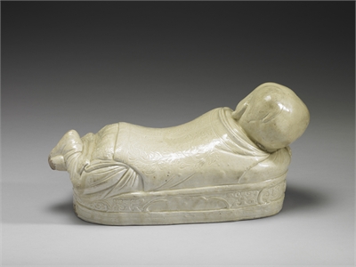 Pillow in the shape of a recumbent child with white glaze, Ding ware